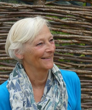 Claire Benn smiling with a wooden background