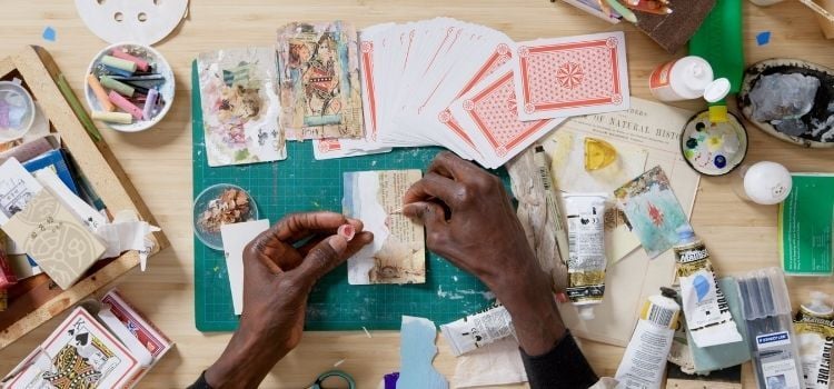 Rober Lee Davis hands making artwork on a card