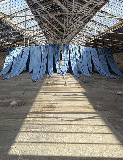 Textiles anchored by heavy stones - Ann Hamilton exhibition