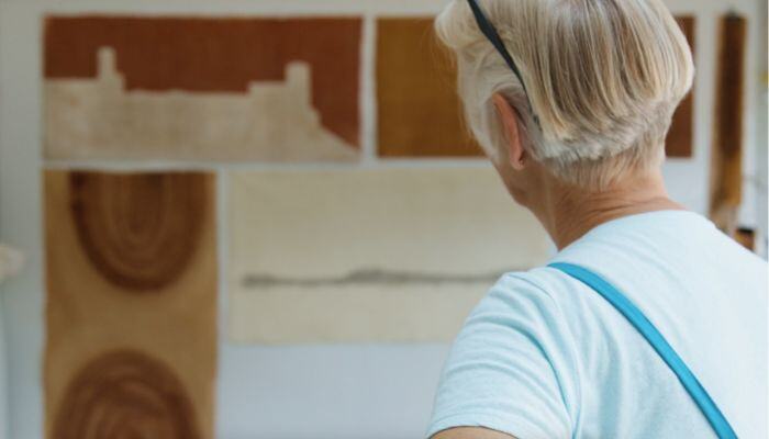 Claire Benn looking at her artwork