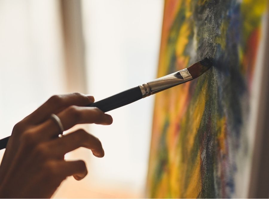 Hand holding painrbrush painting