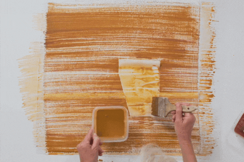 Claire Benn applying soya milk based earth pigments to cloth using a brush
