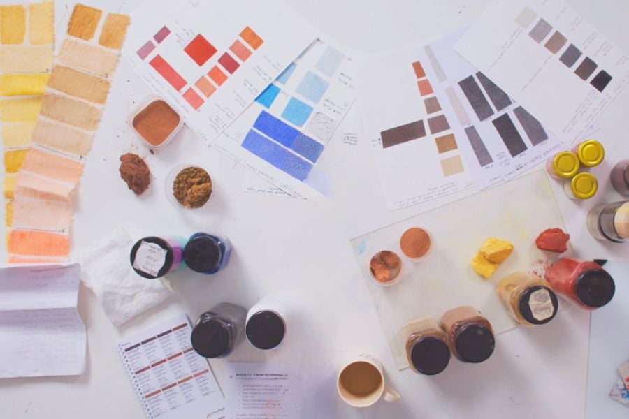 Earth pigment pots, colour samples, laid out on studio table