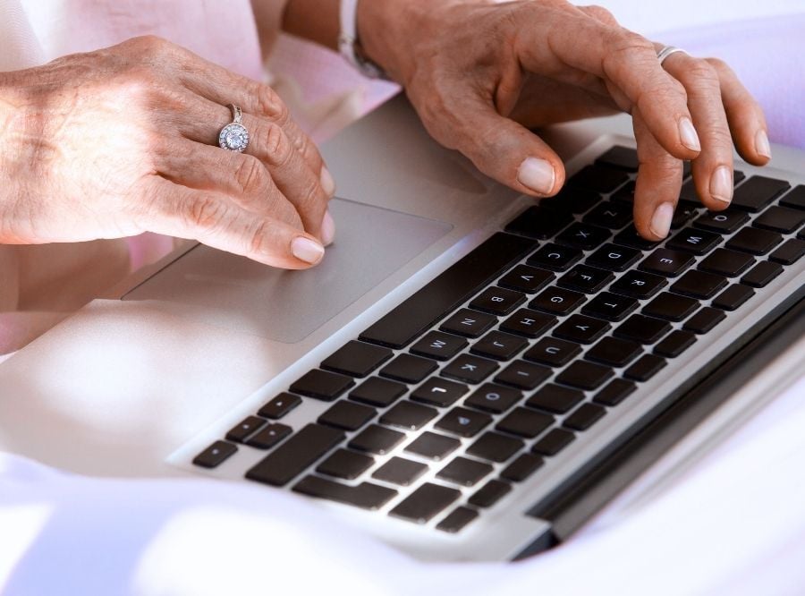 Hands typing on a laptop