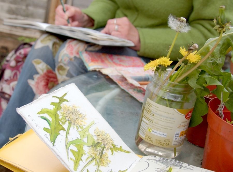 Sketchbook and jar in the foreground, Cas sketching in the background