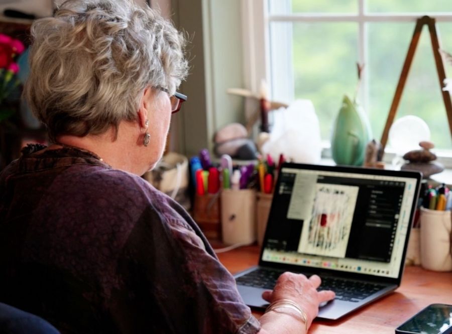 Wen Redmond working on her laptop in her studio