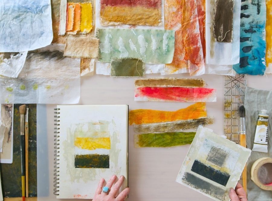 Sketchbook and creative materials spread out on studio table