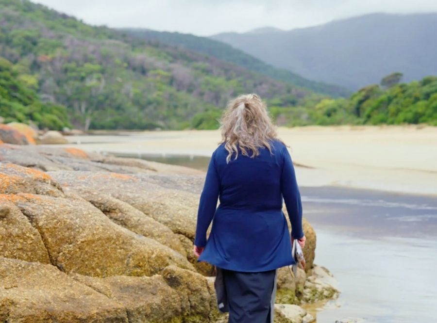 Roxanne Evans Stout walking on the rocks by the water