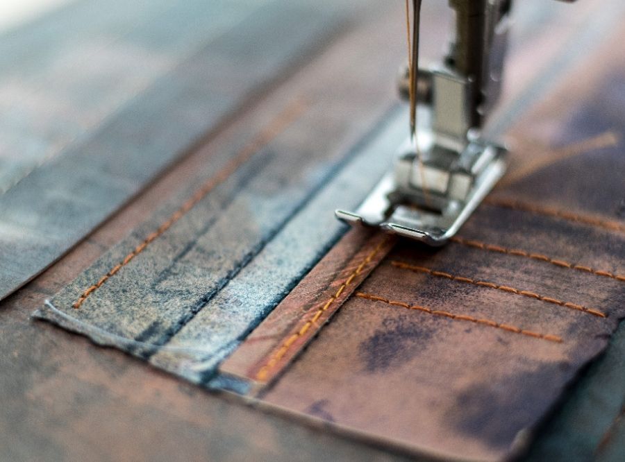 Close up of sewing machine making stitches on artwork